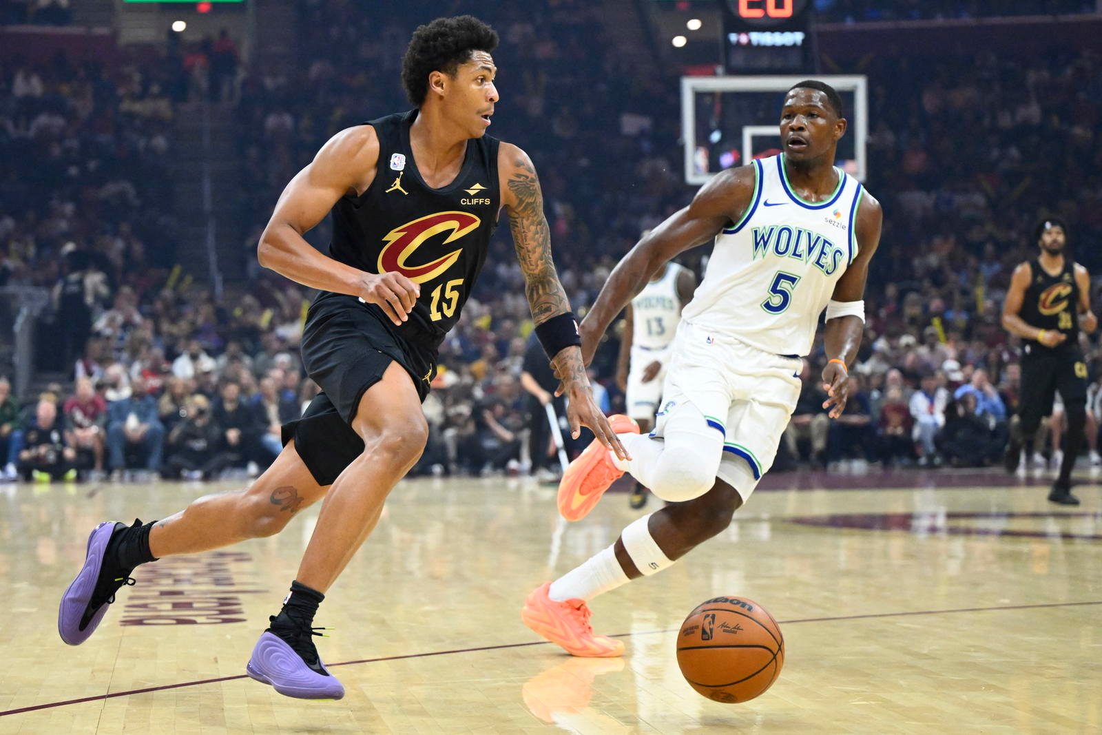 Anthony Edwards, in a white Timberwolves uniform, defends Cleveland rookie Meleek Thomas at Rocket Arena.