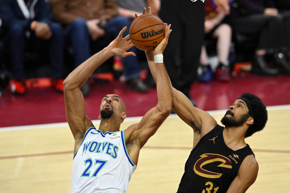 Rudy Gobert, in a white Timberwolves uniform, goes up for the ball against Cleveland's Jarrett Allen.