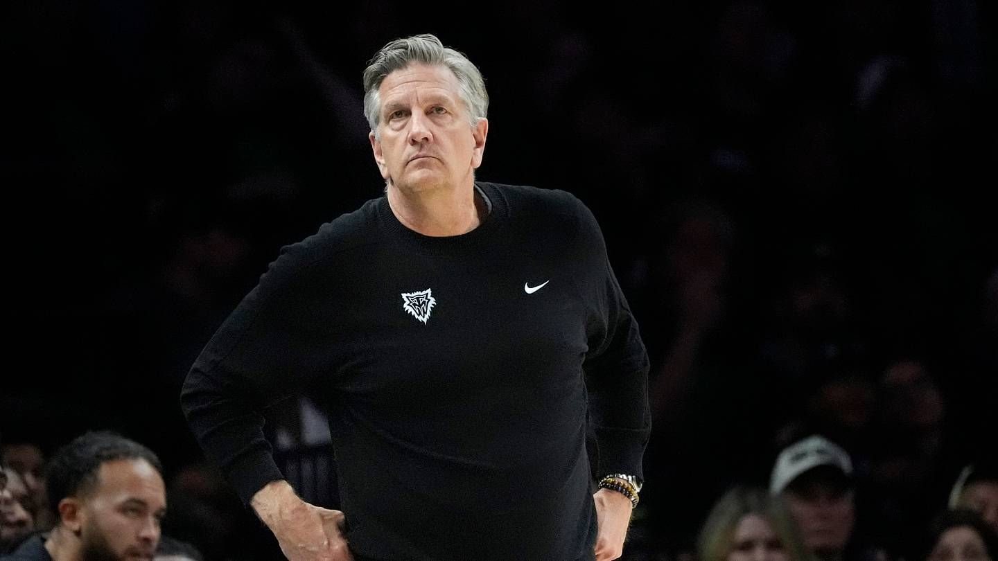 Chris Finch watches the court in a black Timberwolves pullover.