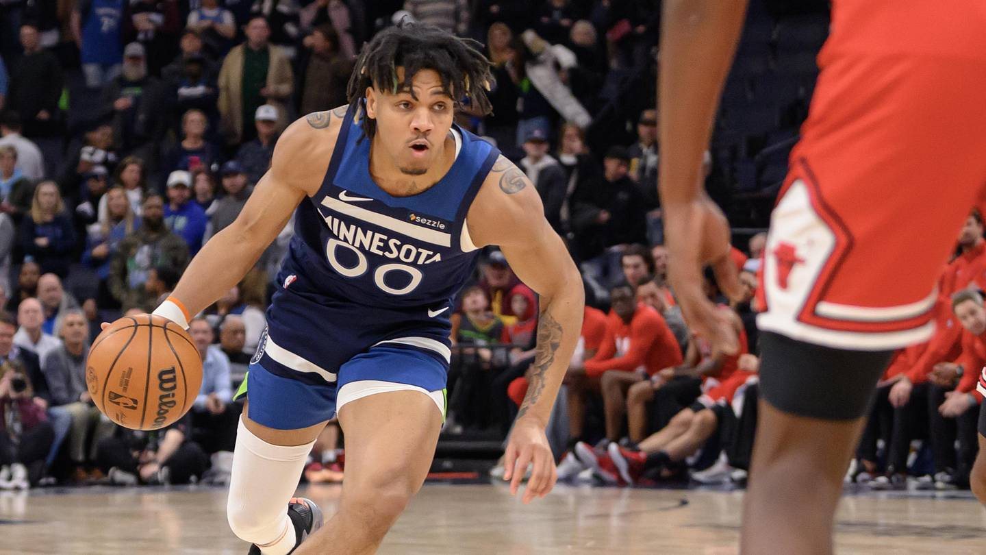 Terrence Shannon Jr. dribbles in a blue Minnesota Timberwolves uniform with a Bulls defender in front of him.