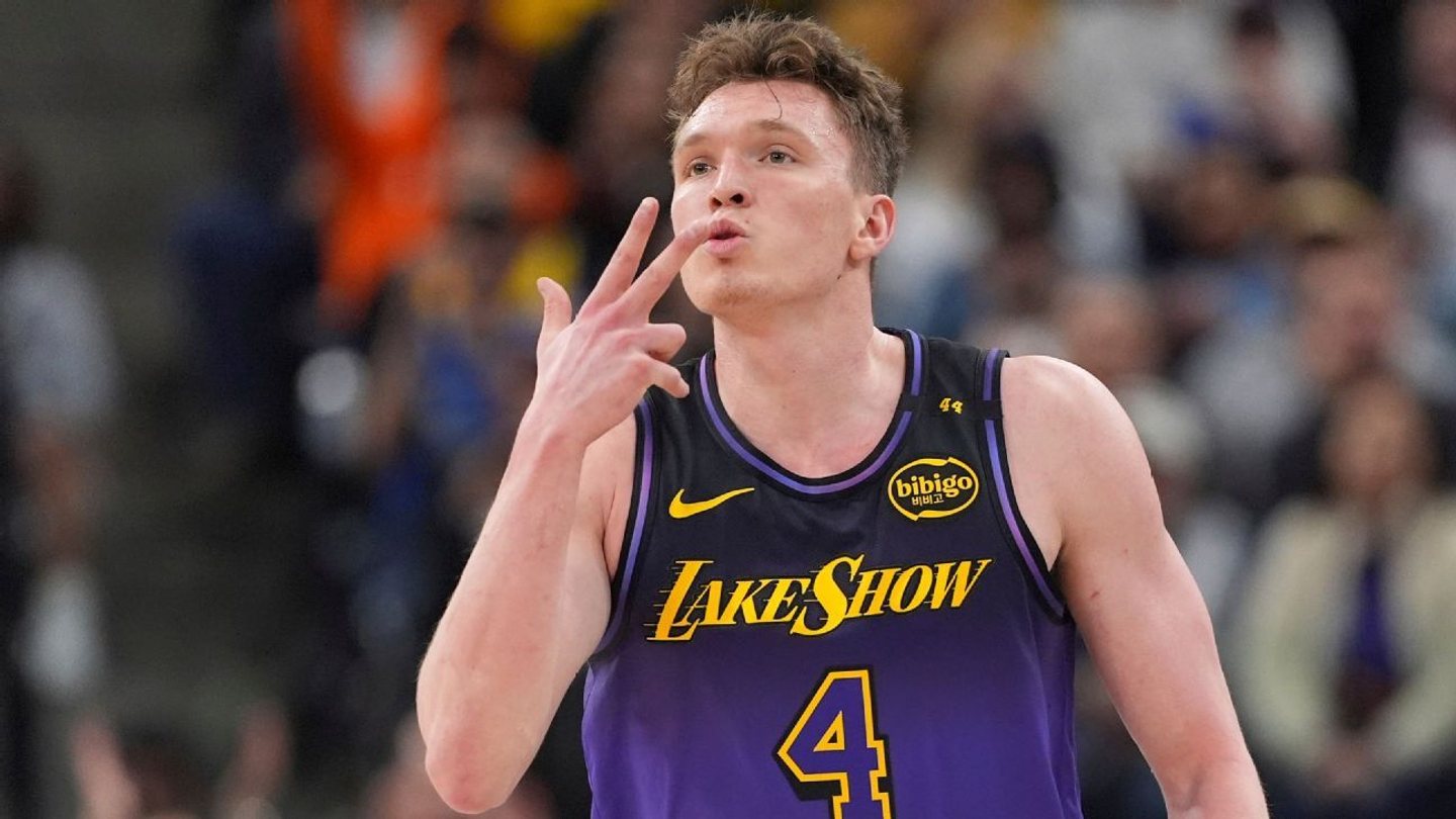 Dalton Knecht raises three fingers in a purple Lakers number 4 uniform.