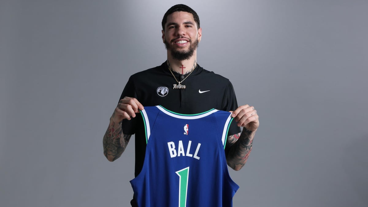 LaMelo Ball holds up a blue Timberwolves jersey with his name and the number 1.
